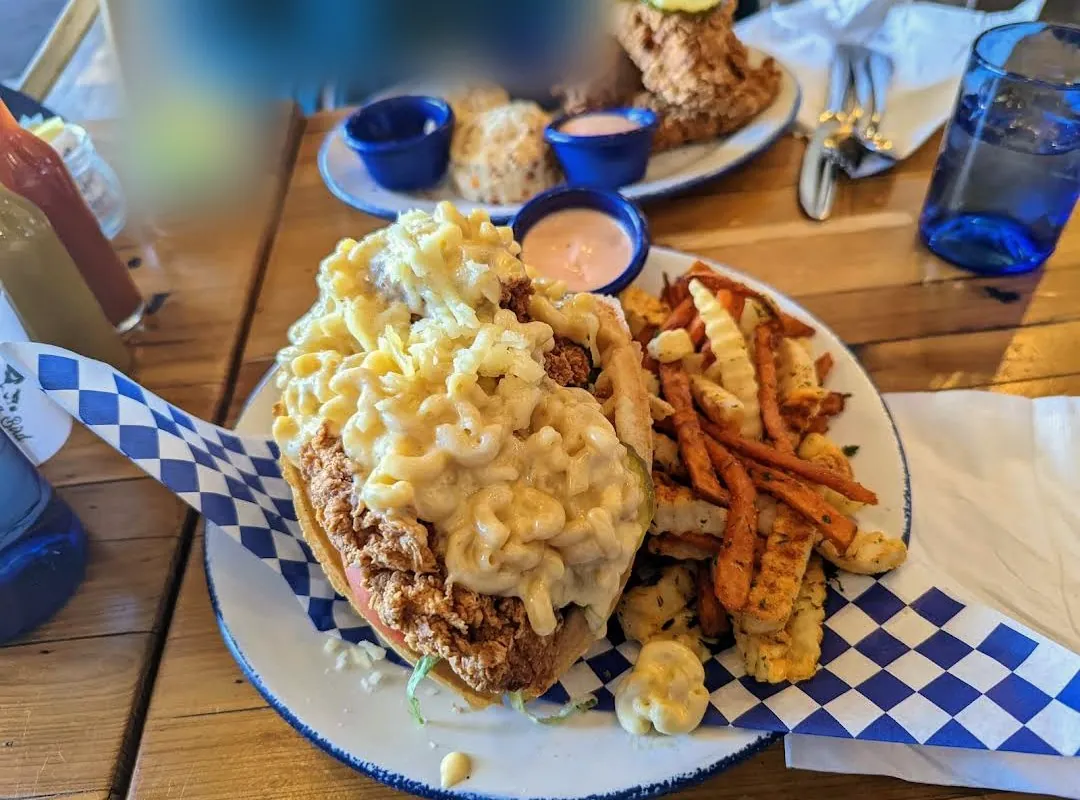 Fried chicken waffle taco topped with mac and cheese, with fries, at Mama Bird Southern Kitchen